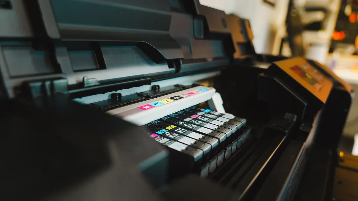 Detailed view of ink cartridges inside a digital inkjet printer in an office setting.