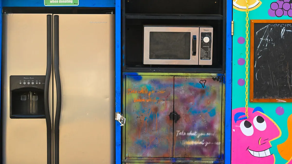 Brightly painted donation spot with a fridge, microwave, and colorful art.