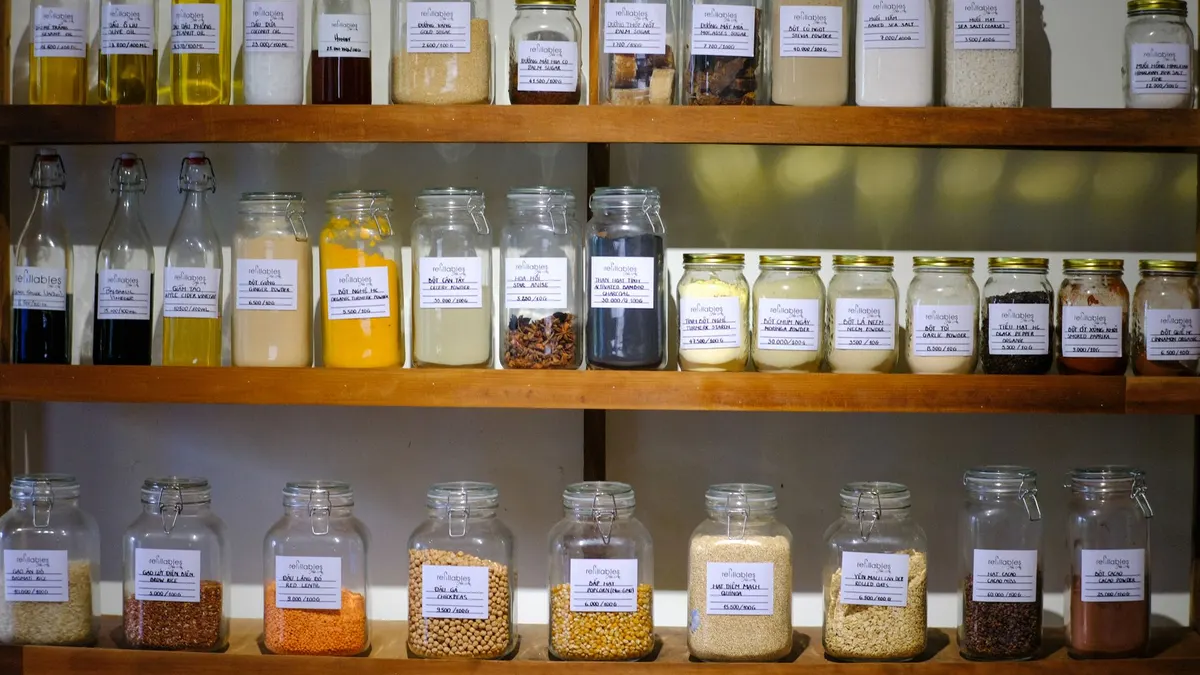 Variety of jars filled with different cooking ingredients neatly arranged on wooden shelves.