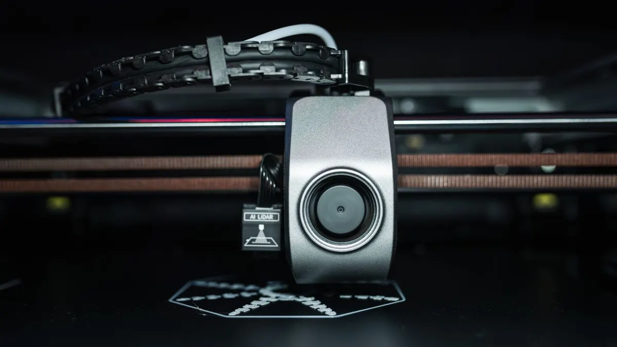 Detailed close-up of a 3D printer extrusion head in focus, showcasing modern technology.