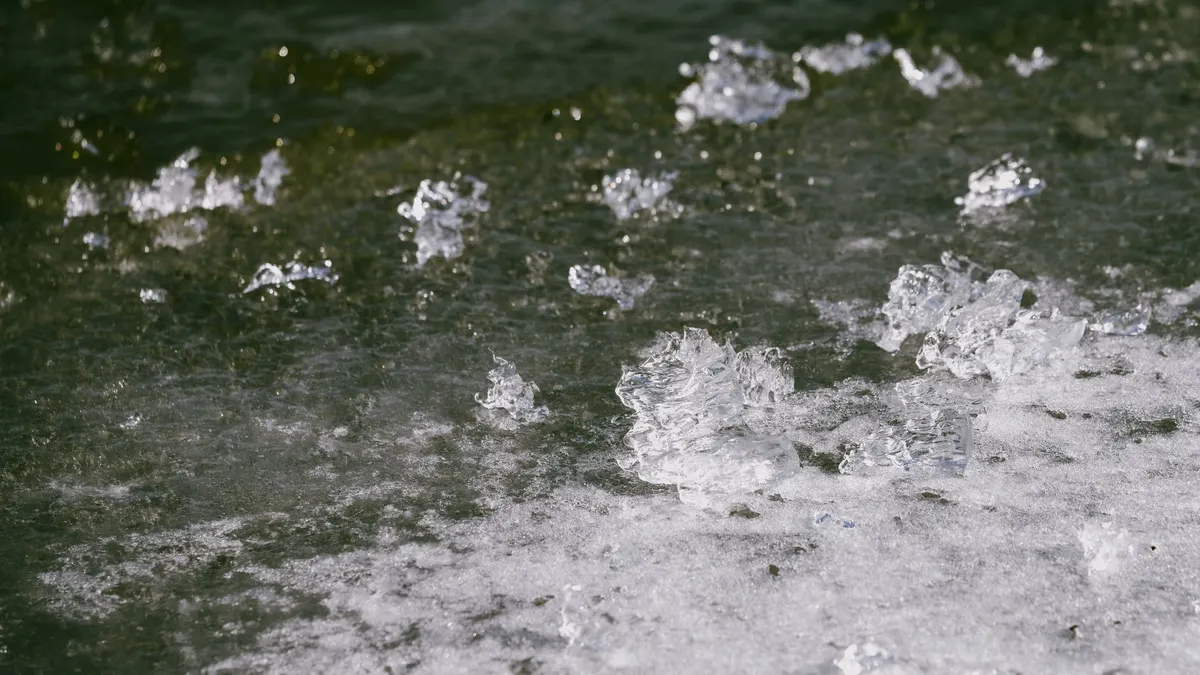Detailed view of ice melting on a water surface, showcasing winter thaw's natural texture.
