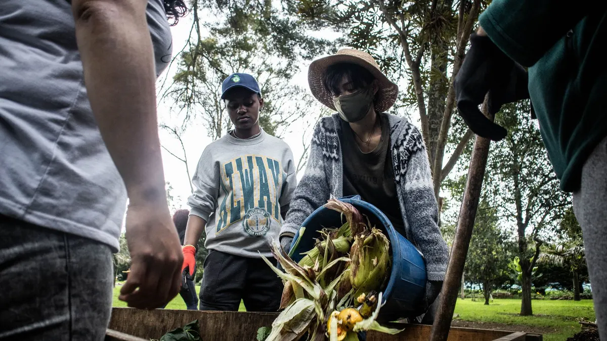 Individuals participate in community composting, promoting urban agriculture in Bogotá.