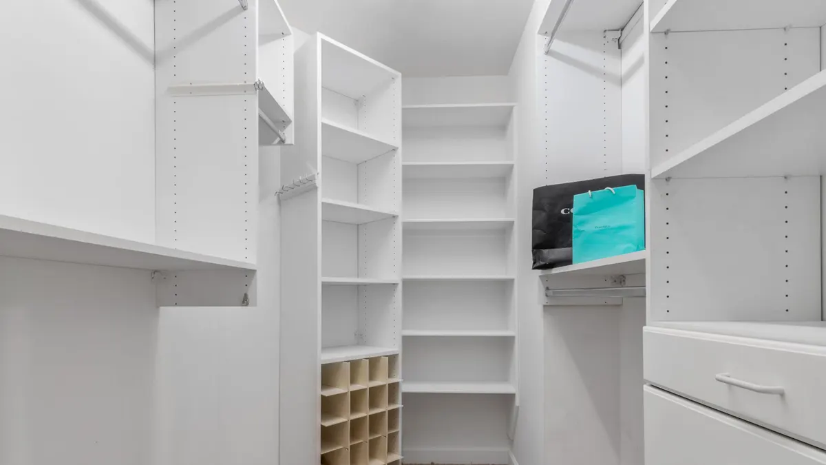 Explore a spacious white closet interior featuring shelves, drawers, and a clean design ideal for modern living.