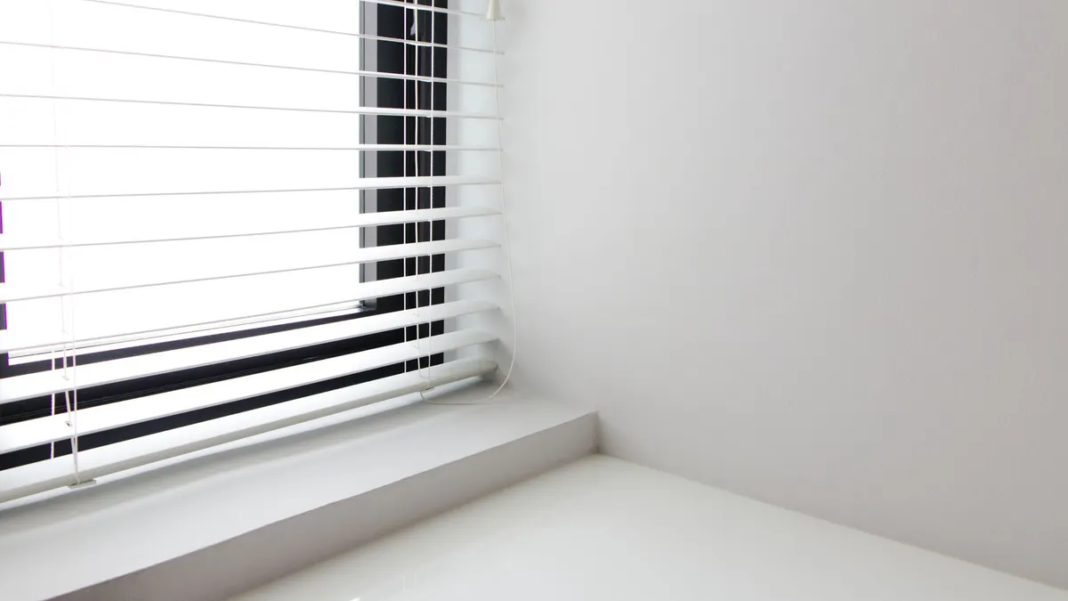 Bright minimalist interior with white window blinds and smooth wall, perfect for modern design.