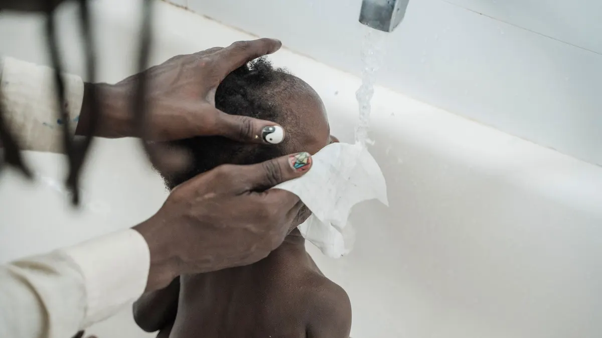 A tender moment of a child being washed during bath time with care and attention.