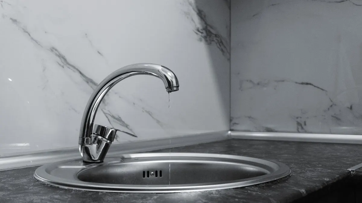 A clean and modern kitchen sink with a chrome faucet, highlighting minimalist design and water conservation.