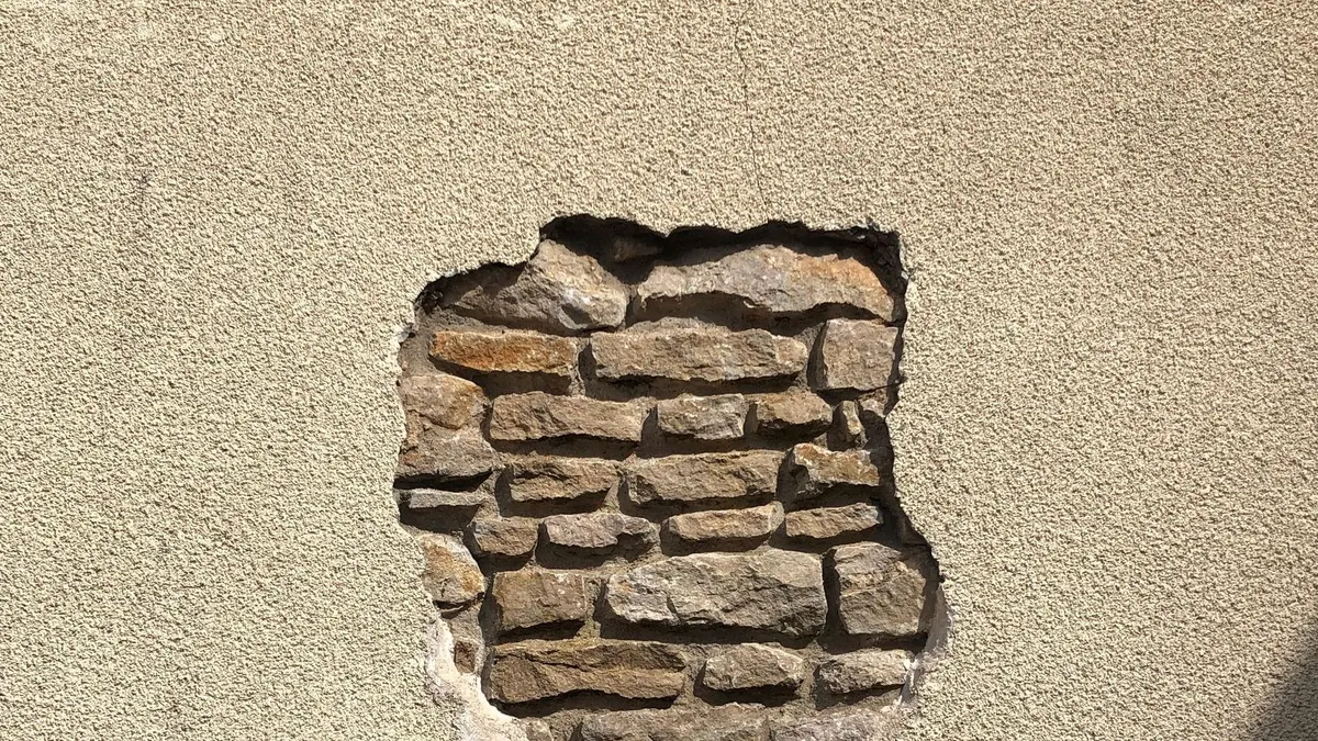 An exposed section of a brick wall in Bourgogne-Franche-Comté, showcasing rustic texture.