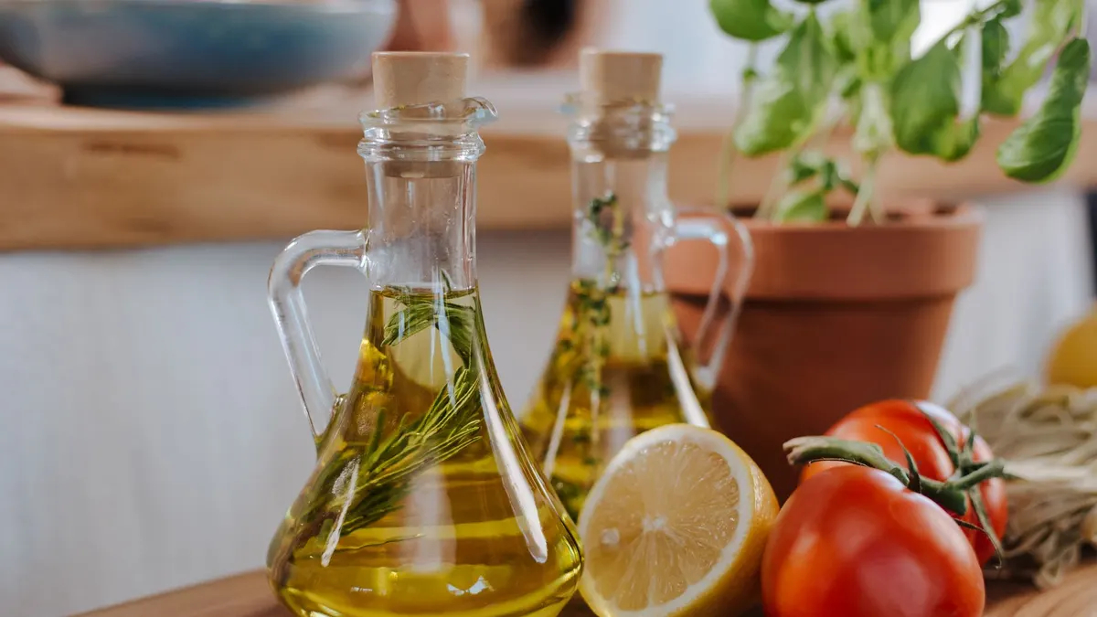 Close-up of fresh ingredients for Italian cooking featuring olive oil and basil.