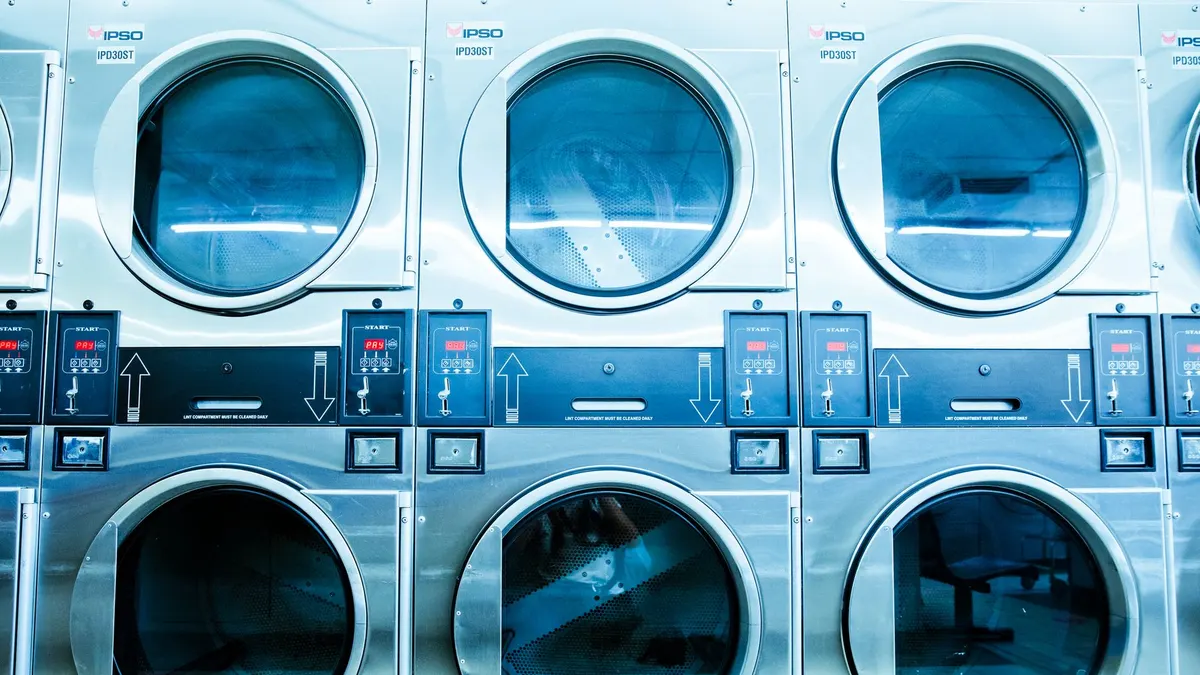 A row of modern washing machines in a launderette, showcasing contemporary laundry technology.