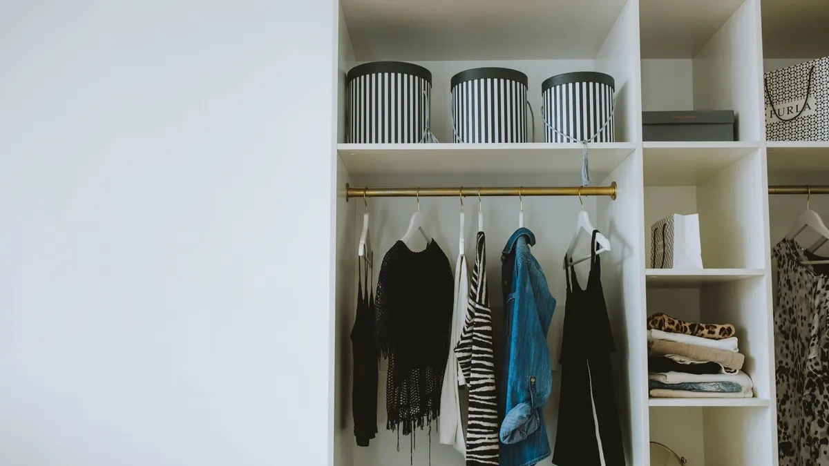 Organized wardrobe with trendy clothes, hangers, and storage boxes.