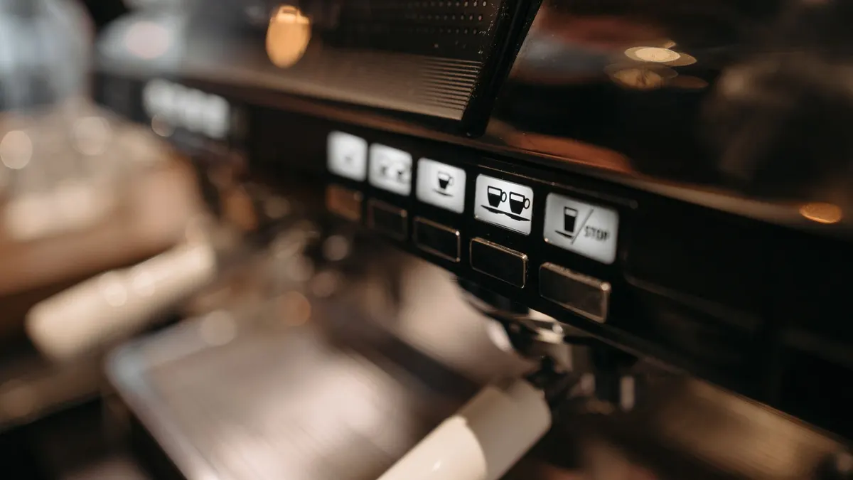 Detailed view of espresso machine panel in a cafe setting, highlighting coffee brewing controls.