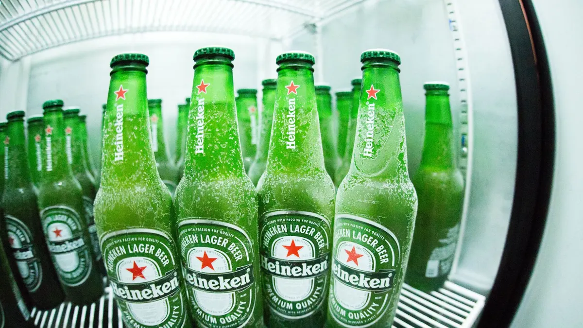 Frosted Heineken beer bottles in a refrigerator showcasing the refreshing coolness.